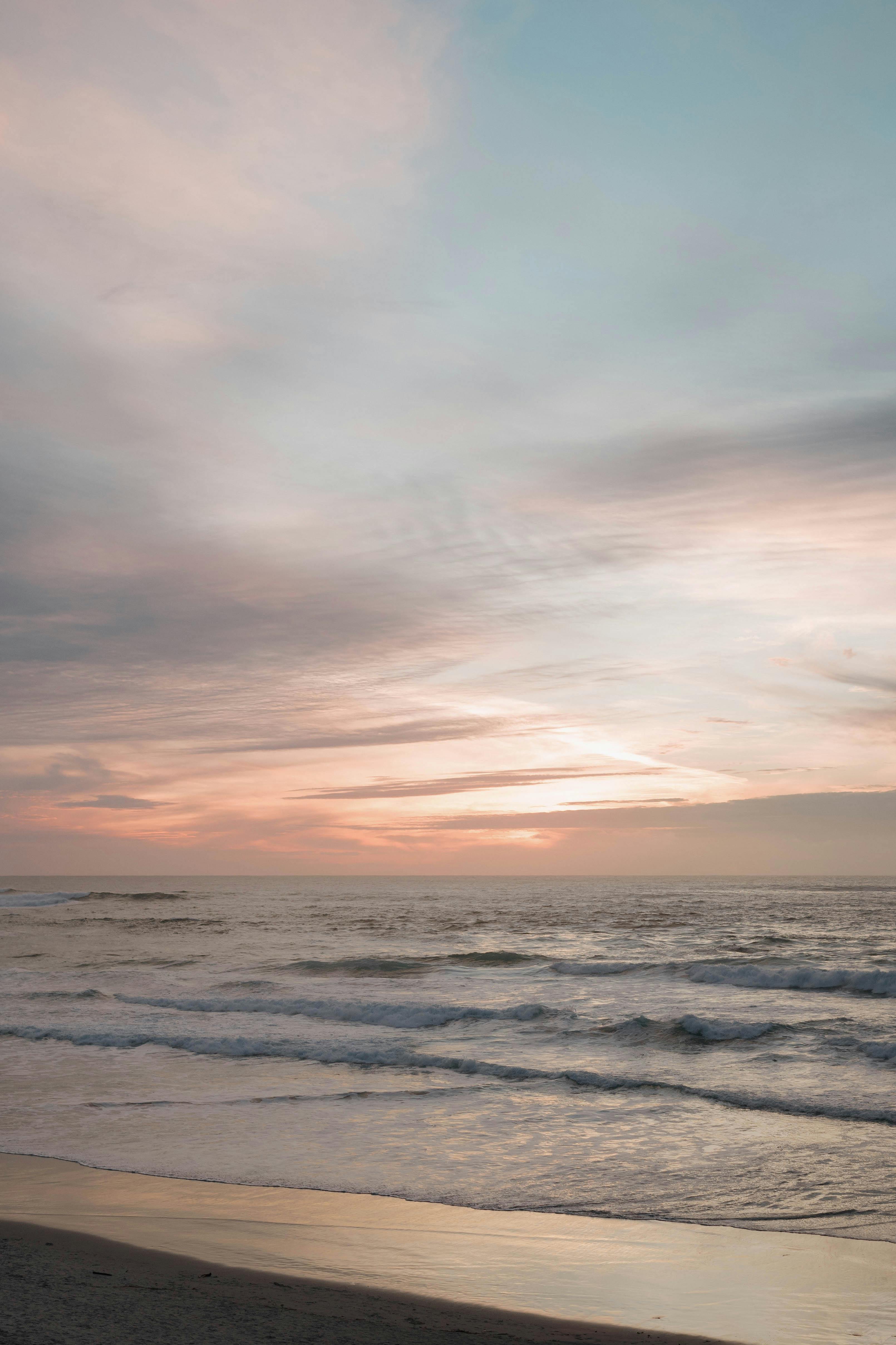 Serene sunset at Carmel Beach, California, with pastel skies and gentle waves.