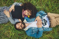 一对年轻夫妇躺在郁郁葱葱的田野上，一起享受着宁静的时光