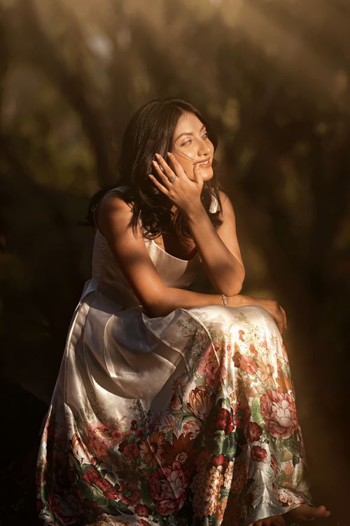 Free A woman in a floral dress enjoys the warm sunlit ambiance, exuding a dreamy atmosphere and a sense of tranquility. Stock Photo