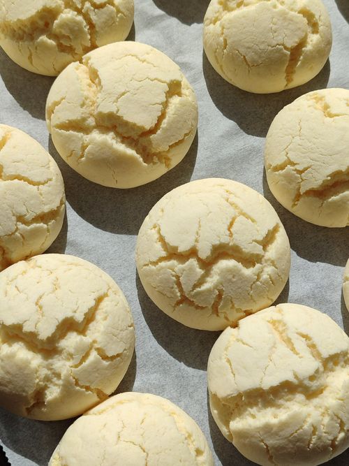 Free Freshly baked sugar cookies cooling on parchment paper, perfect for a sweet treat. Stock Photo