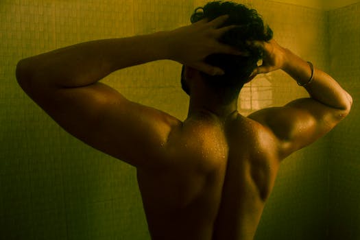 Muscular man in a cinematic shower scene with dramatic lighting and green tones.