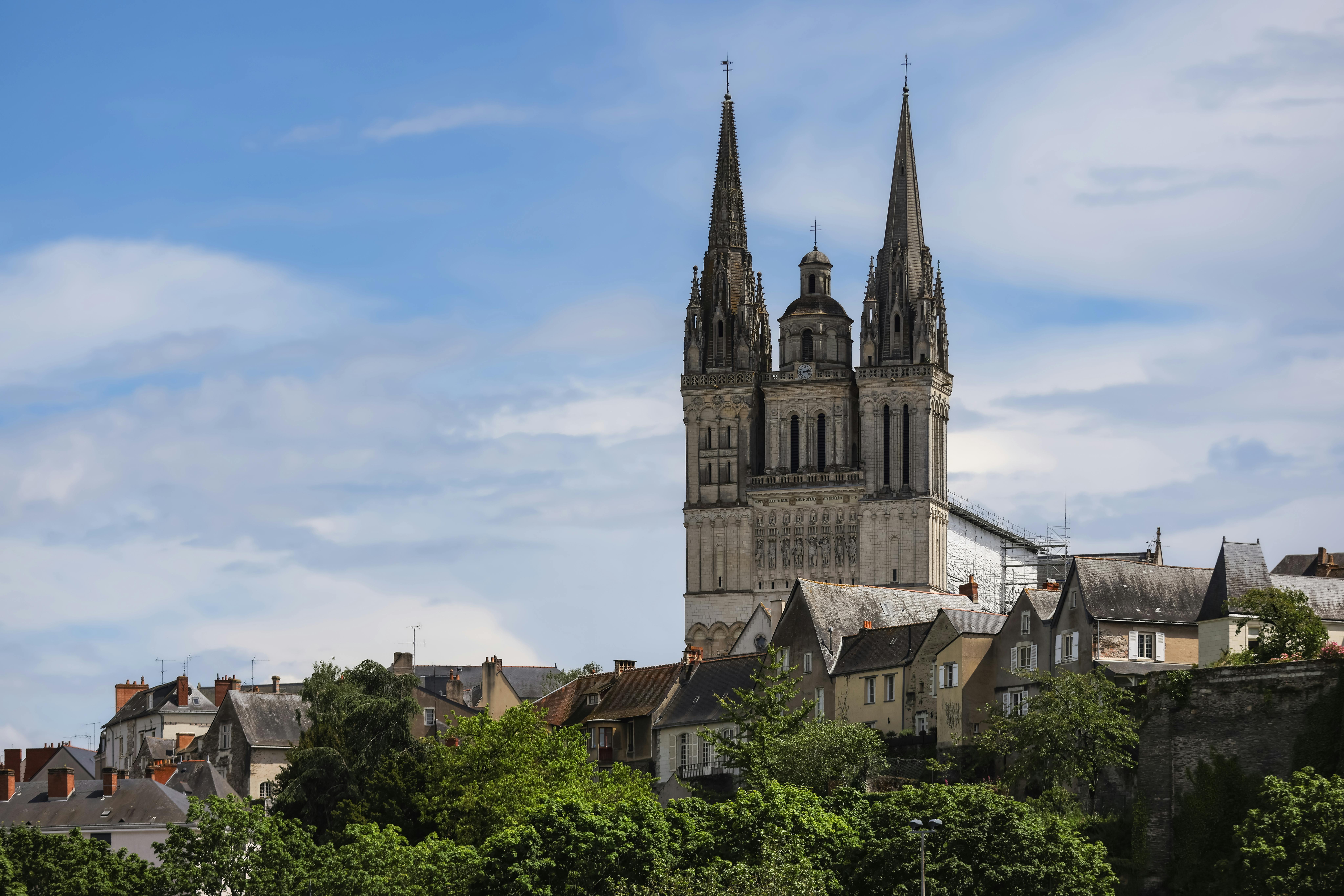 Angers Cathedral's towering spires under a vibrant sky in Pays de la Loire, France.