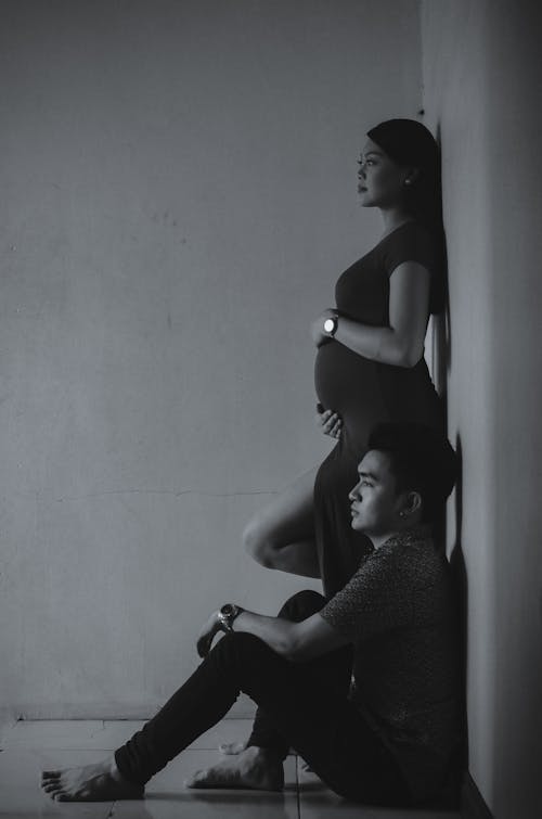 Grayscale Photography of Man and Woman Leaning on Wall