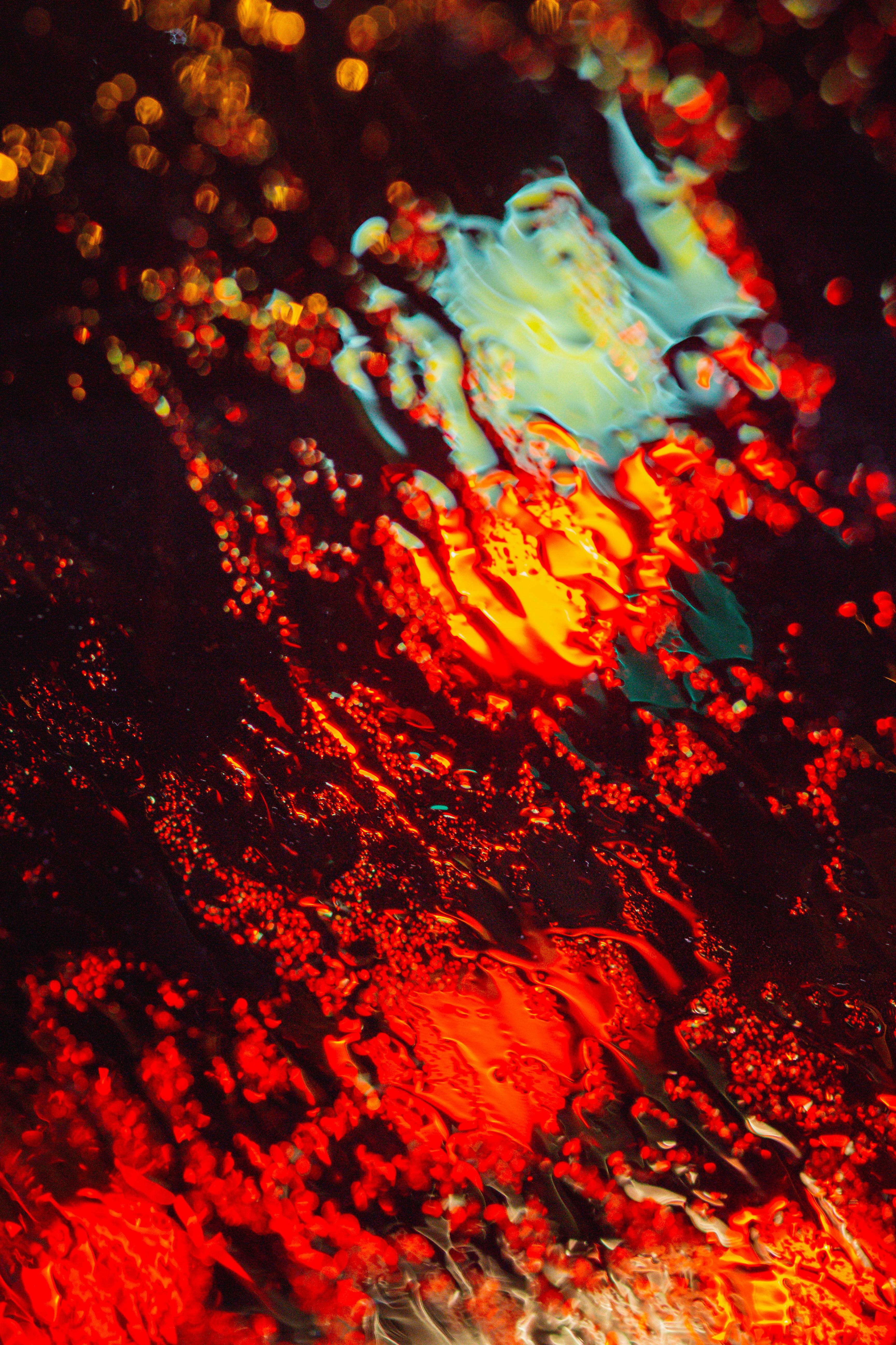Colorful abstract image with vibrant blurry bokeh and wet glass effect, evocative of a mystical evening atmosphere.