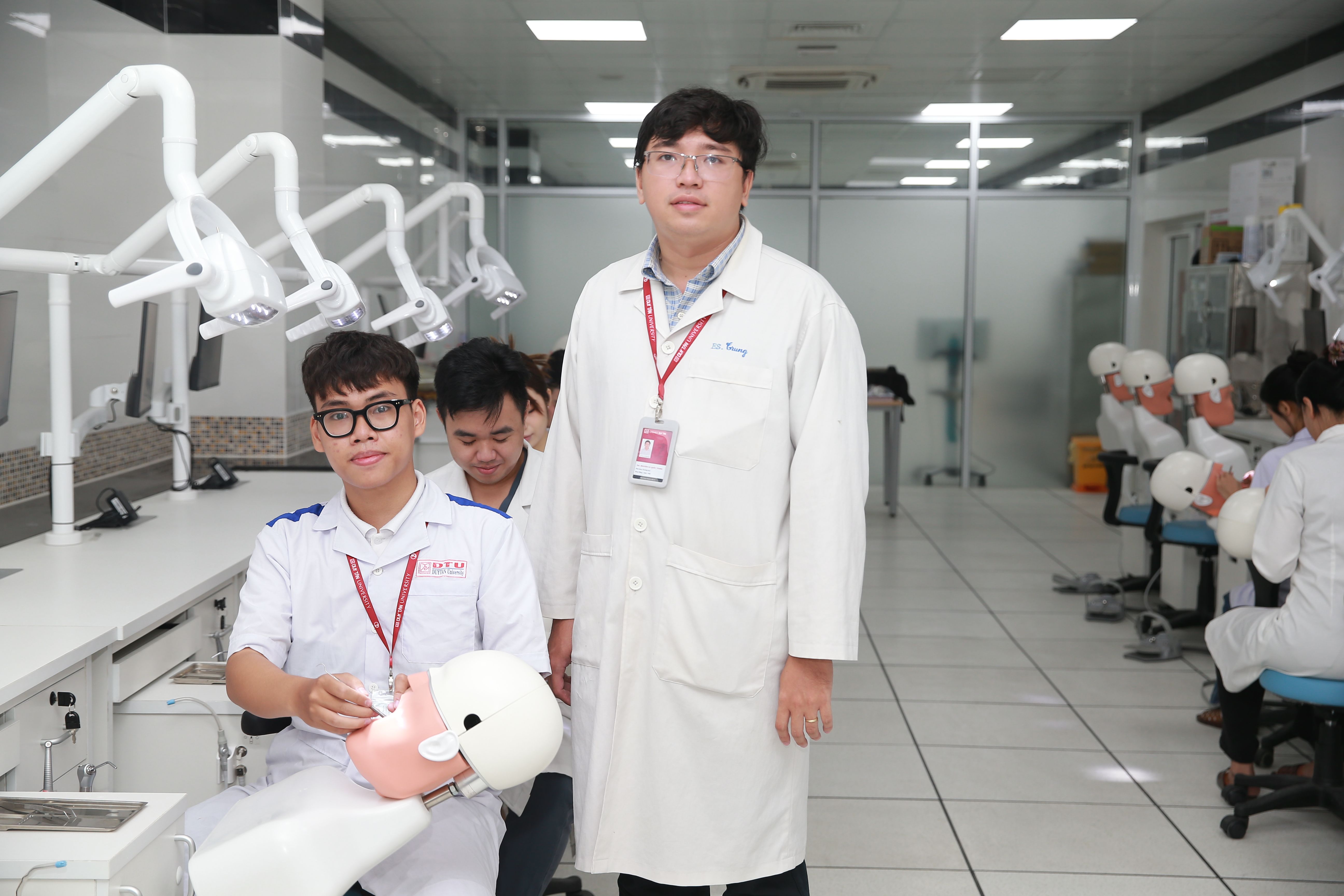 Dental students practicing on mannequins under supervision in a clinical lab setting.