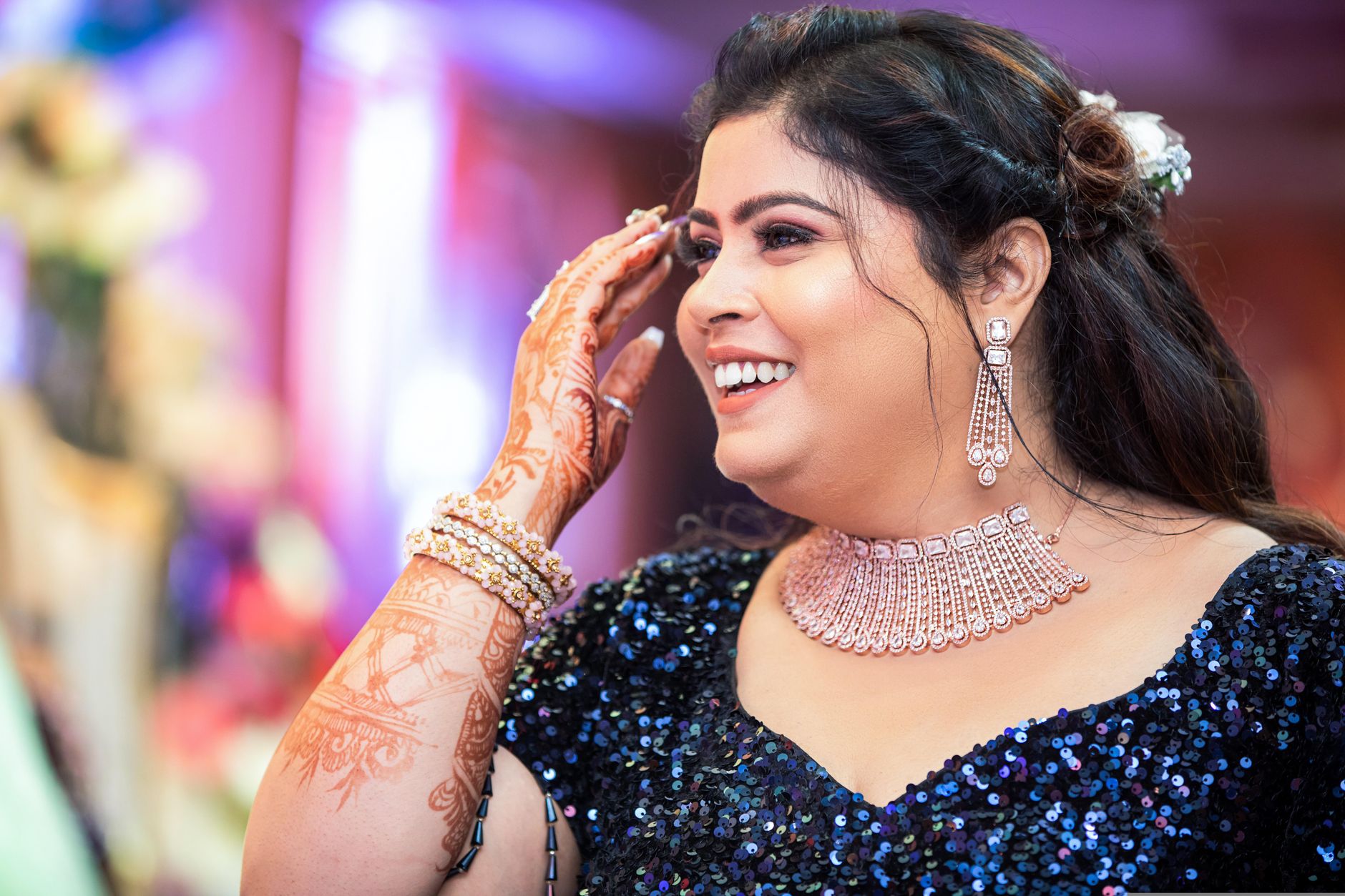 Smiling woman adorned in elegant jewelry at a festive occasion in Bengaluru, India.