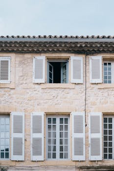 Charming stone building with shuttered windows in Lourmarin, Provence, exemplifying Provencal style.
