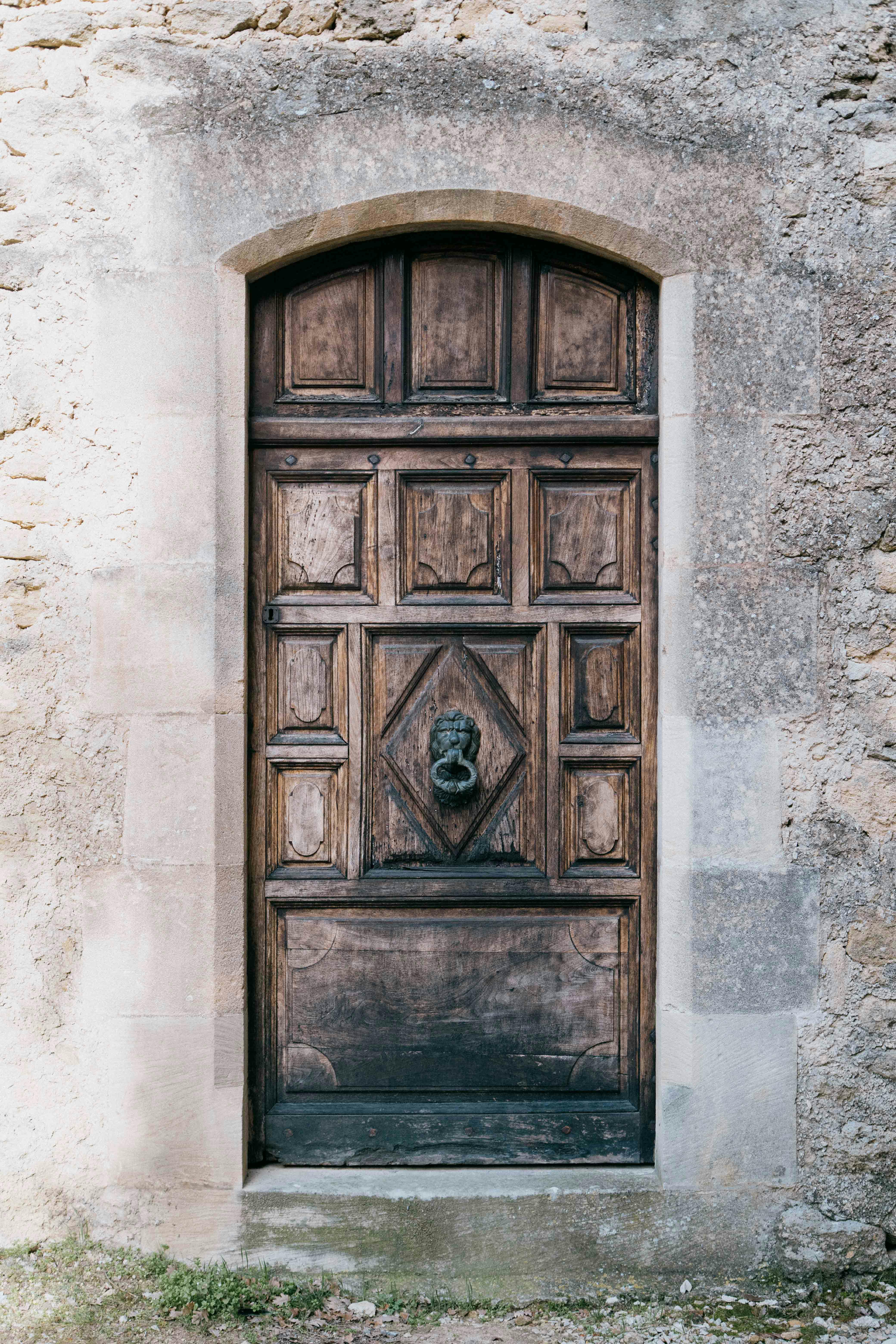 Charming rustic wooden door set in stone, capturing Provence's architectural elegance.