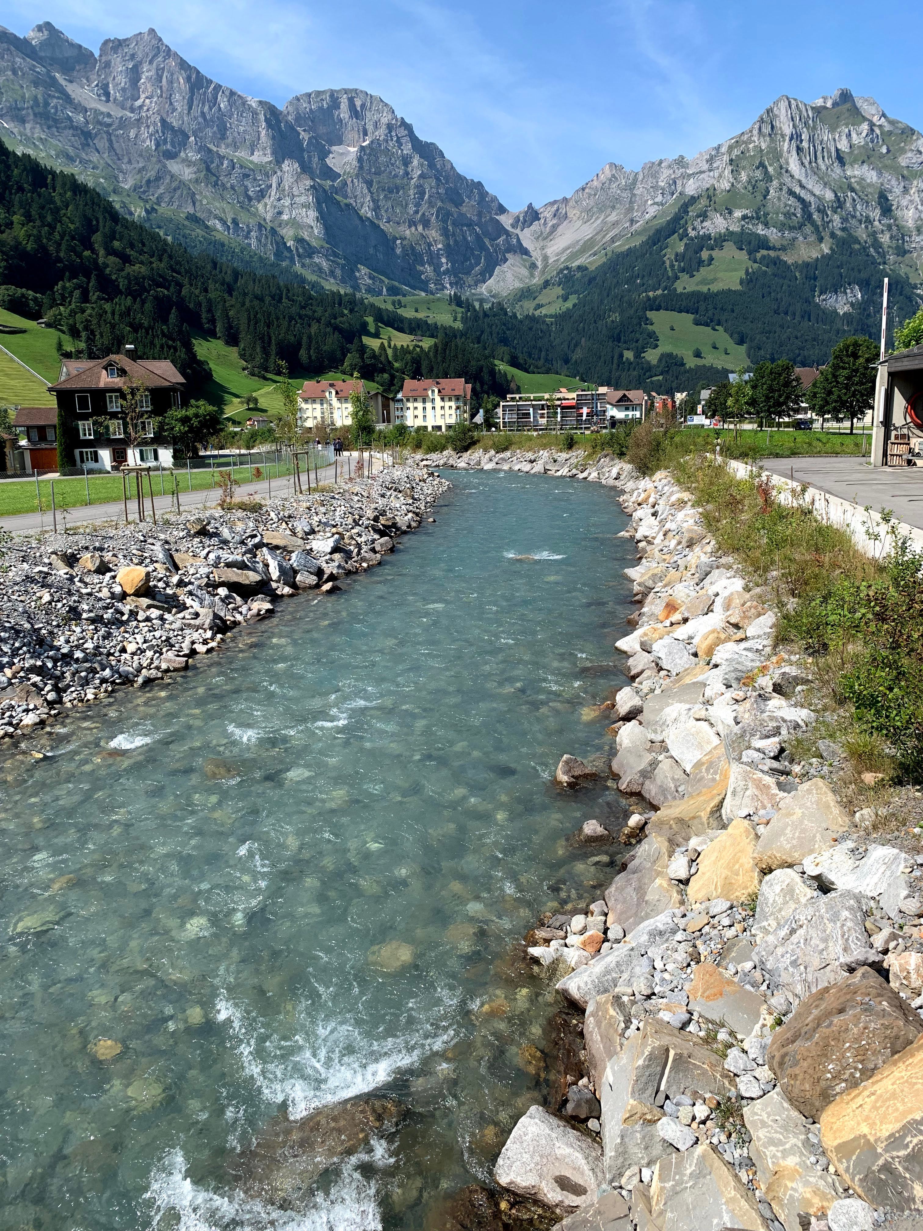 Beautiful Swiss alpine view with a clear river flowing through a picturesque village.