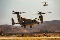 Gray Military Aircraft Flying over Green Grass Field