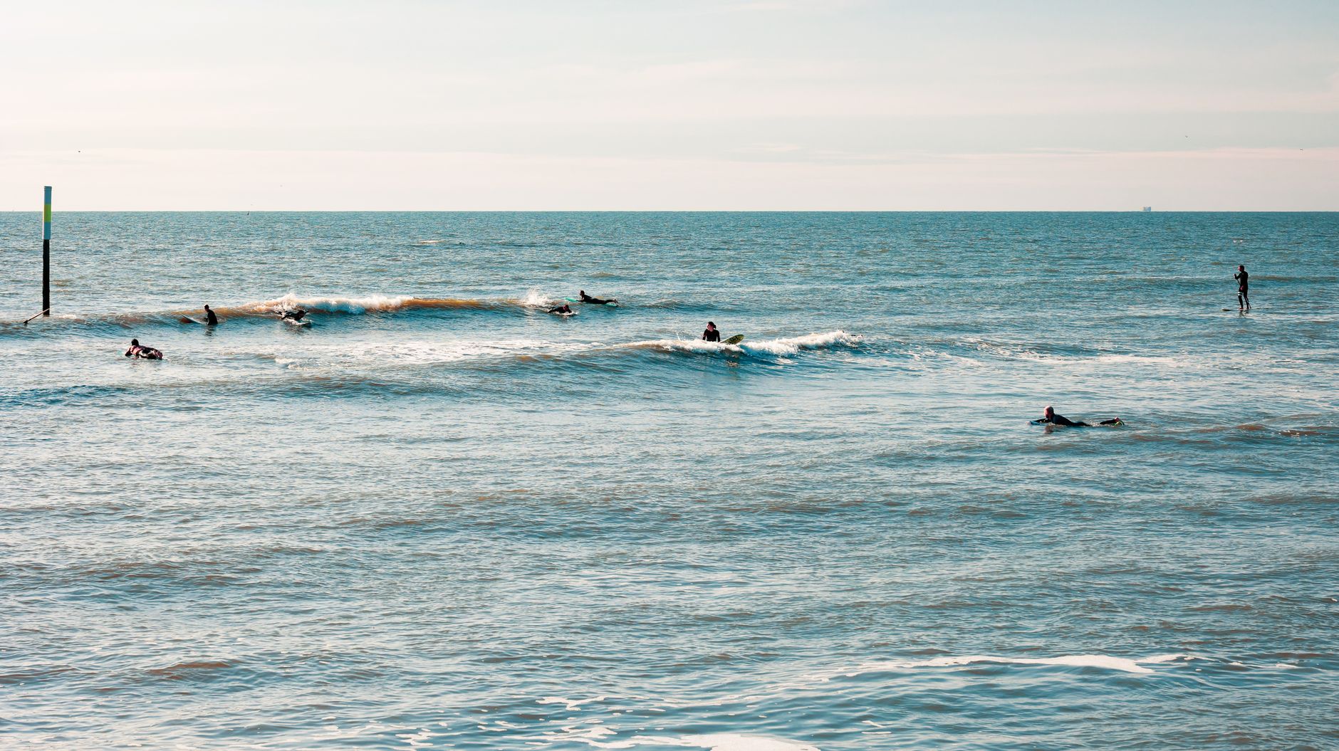 Surfers genieten van de golven bij Sankt Peter-Ording, Duitsland op een zonnige dag.
