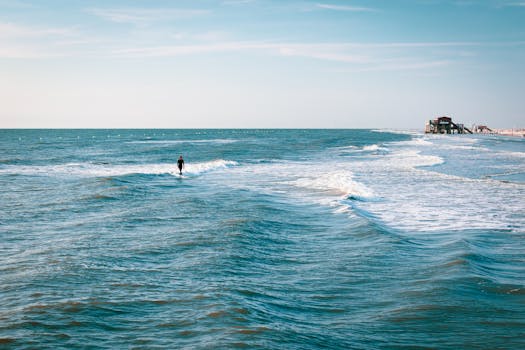 A surfer enjoying the summer waves at Sankt Peter-Ording beach in Germany.