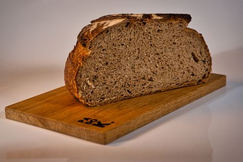Free A slice of rustic artisan bread on a wooden board, capturing the essence of traditional baking in a Berlin bakery. Stock Photo