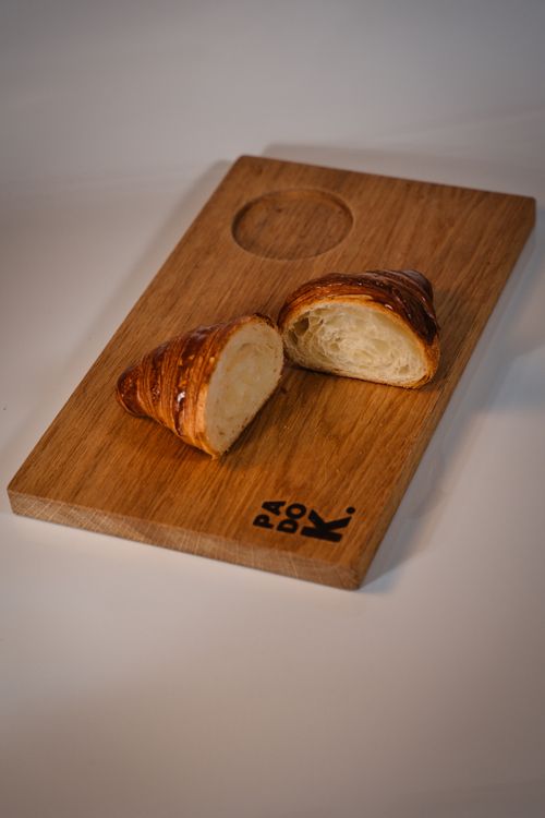 Free Close-up of a fresh croissant on a wooden board, perfect for gourmet food imagery. Stock Photo