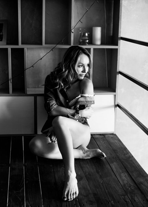 Free Elegant black and white portrait of a woman sitting by the window in a modern room. Stock Photo