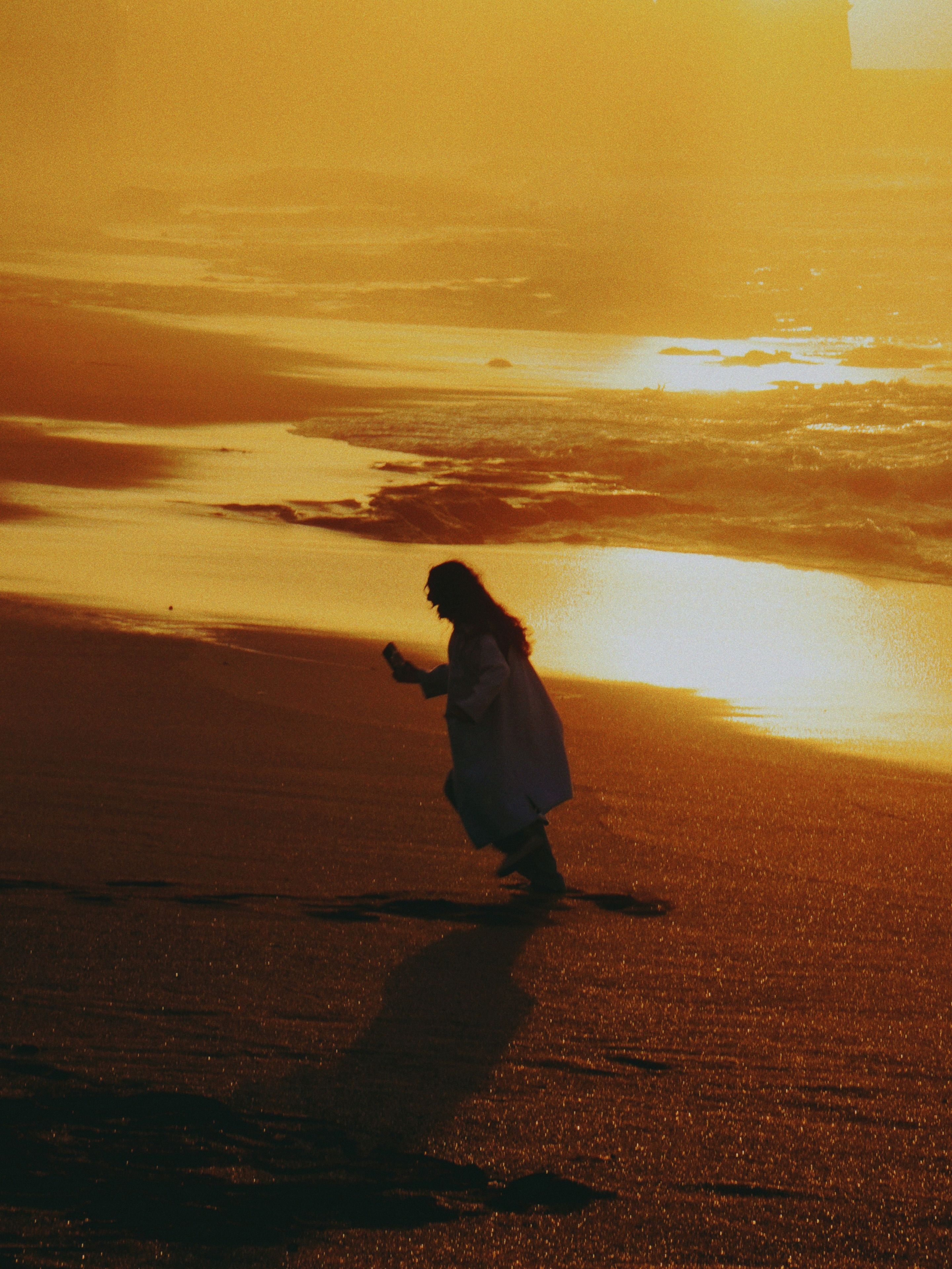 Silhouette of Woman Walking on Moroccan Beach at Sunset · Free Stock Photo