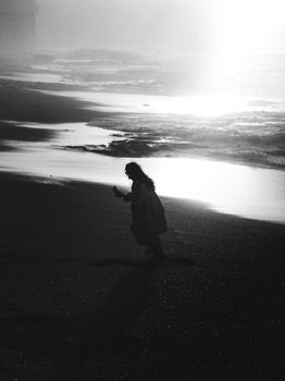 Dramatic silhouette of a person on Rabat beach at sunset, creating a tranquil and moody atmosphere.