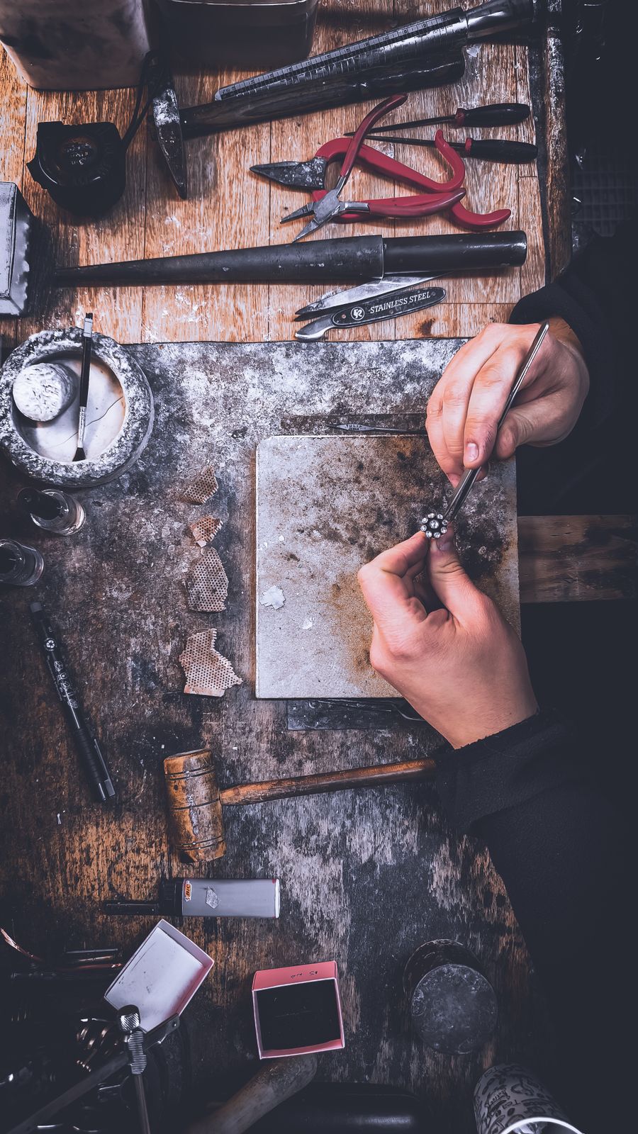 Artisan polishing jewelry on a workbench