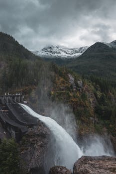 A powerful dam spillway amidst mountain forests in the United States.
