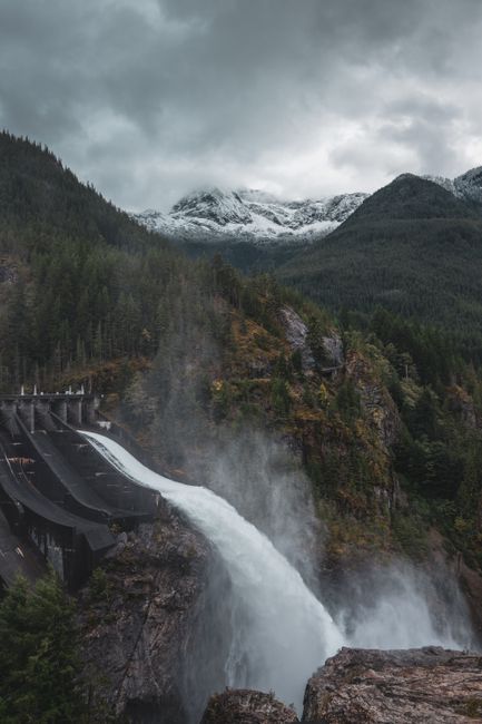 A powerful dam spillway amidst mountain forests in the United States.
