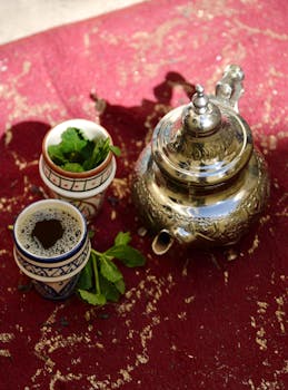 Authentic Moroccan mint tea set with silver teapot and cups on a vibrant red rug, Fès, Morocco.