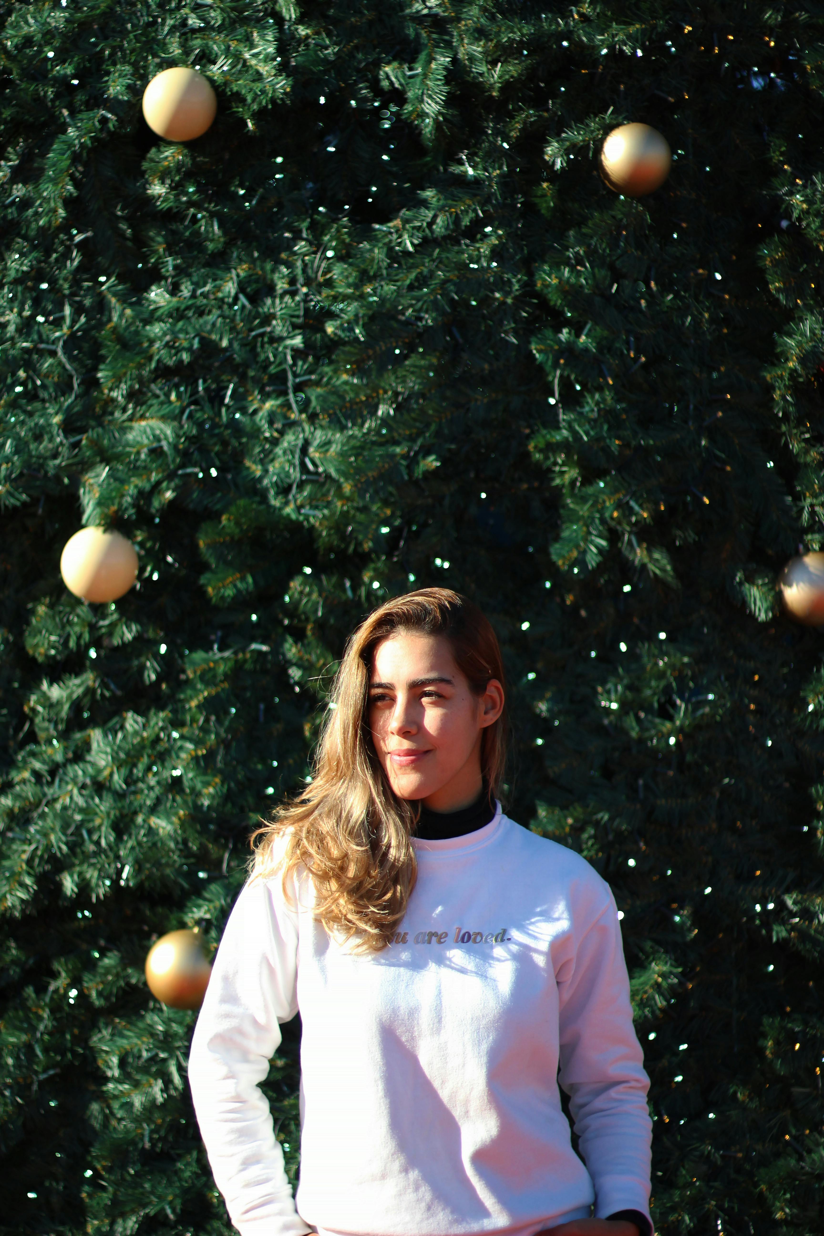 young woman smiling by festive christmas tree