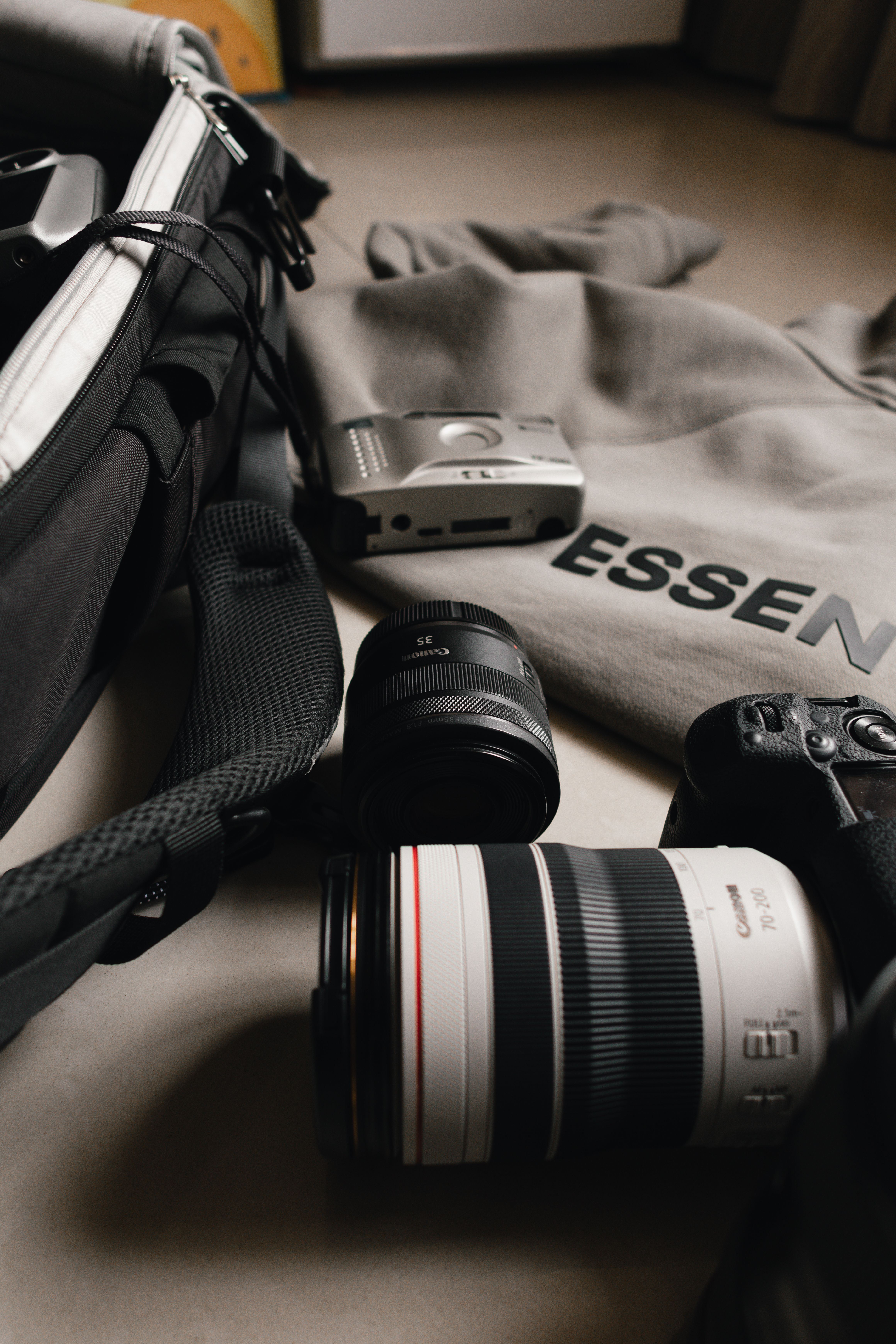 Close-up of various camera gear, including DSLR and lenses, on a desk.