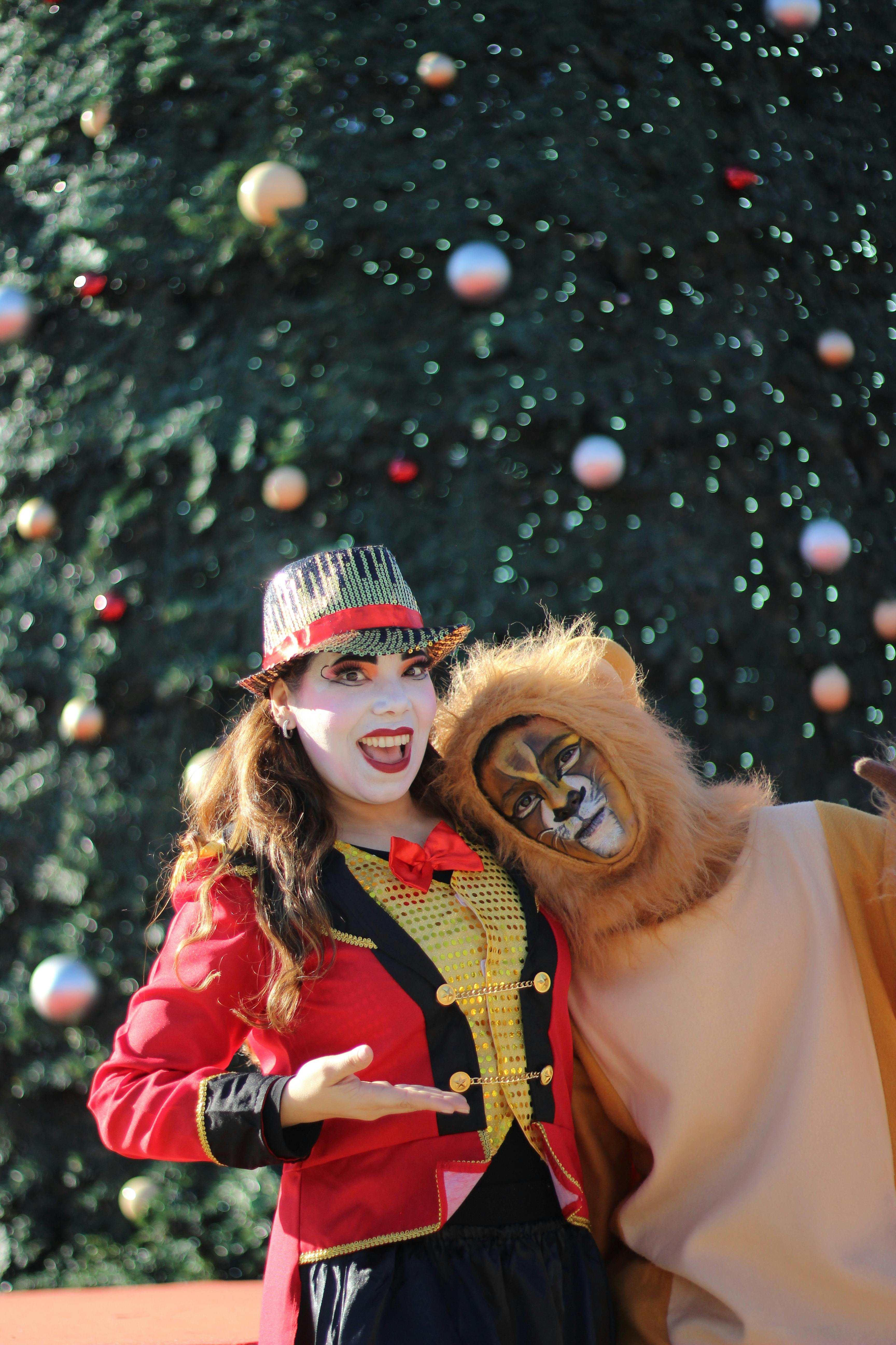 Gratuit Deux artistes de cirque en costumes colorés avec en toile de fond un sapin de Noël. Photos