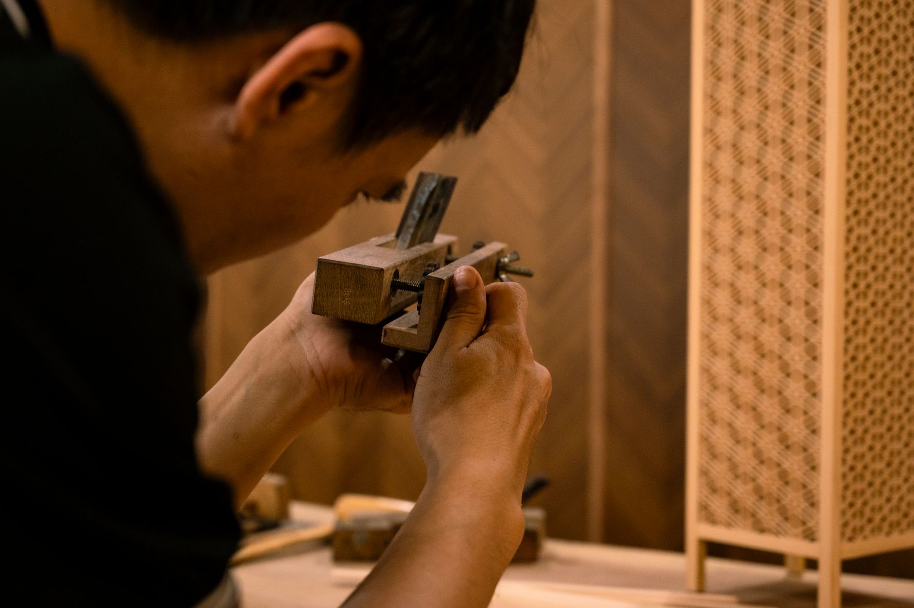 Skilled artisan working on traditional wood joinery technique indoors.