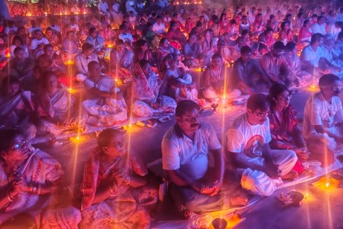 Free People gathered in a candlelit religious ceremony in Kachua, West Bengal, India, creating a serene atmosphere. Stock Photo