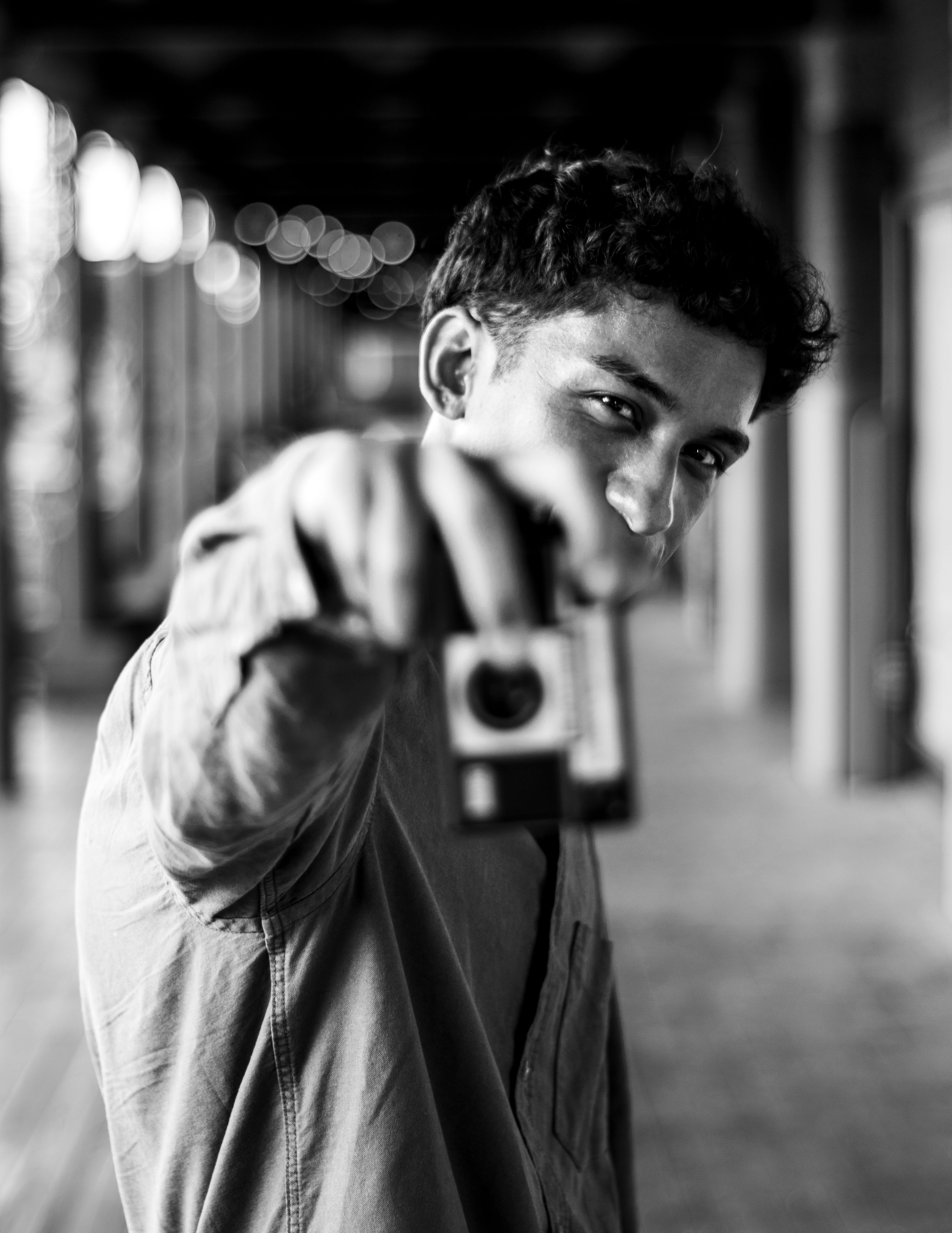 Artistic black and white portrait of a man holding a vintage camera in Buenos Aires.