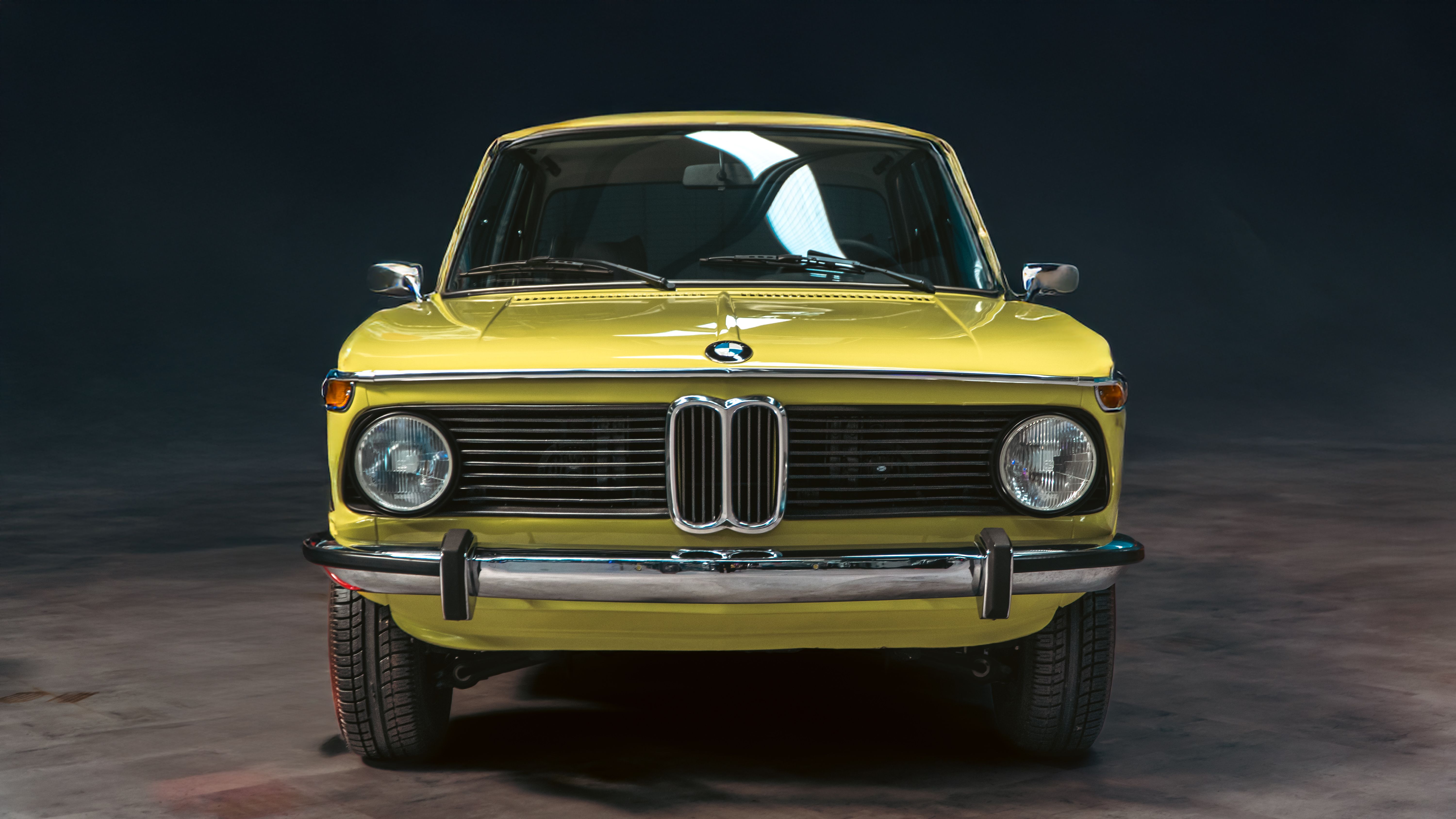Front view of a vintage BMW car with chrome details in a studio setting.