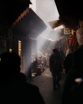 Sunlight filters through a bustling traditional market alley, creating an atmospheric vibe.