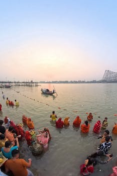 Devotees during Chhath Puja at the Ganges River in Kolkata, facing the sunrise.