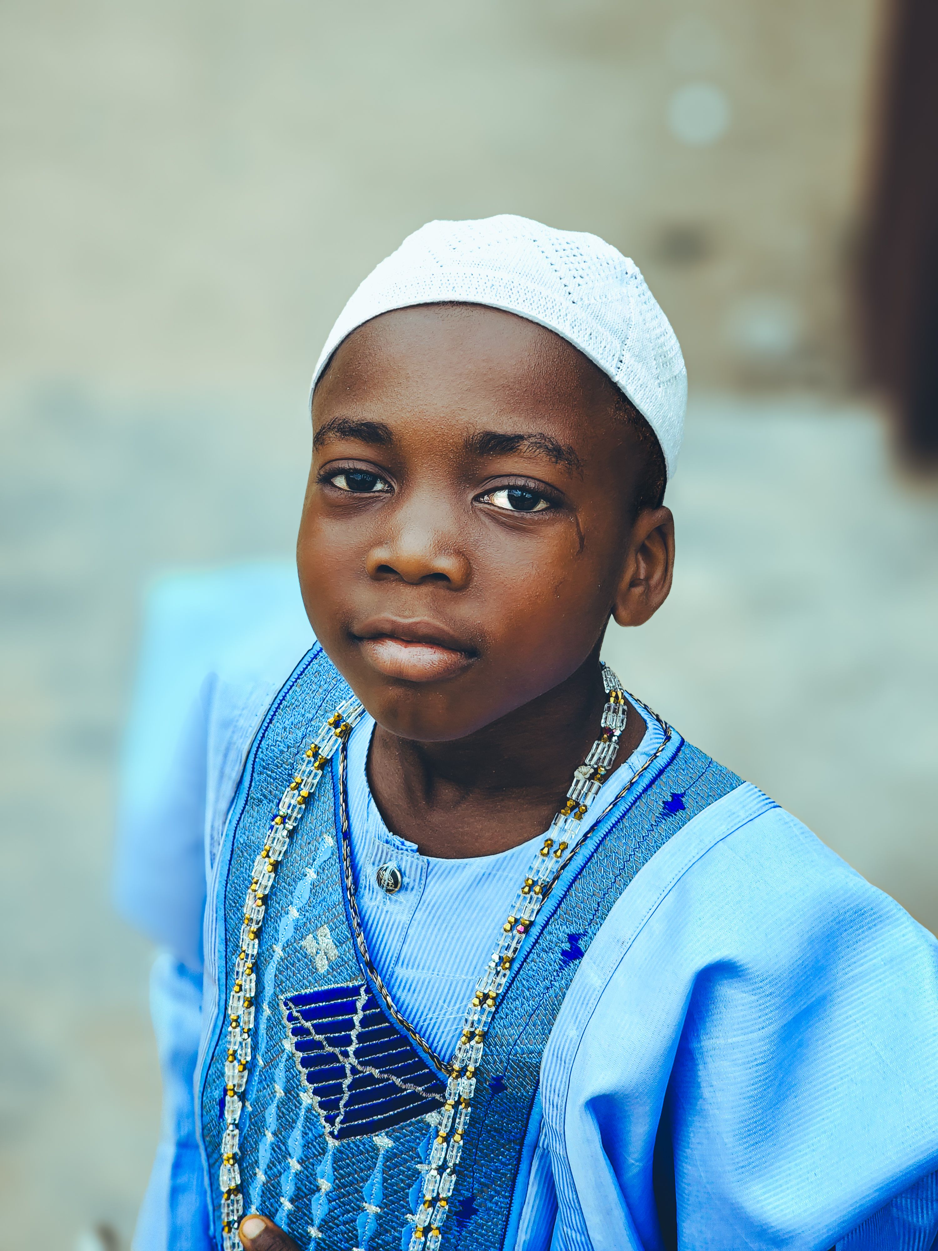 Young Boy in Traditional Blue Attire Outdoors · Free Stock Photo