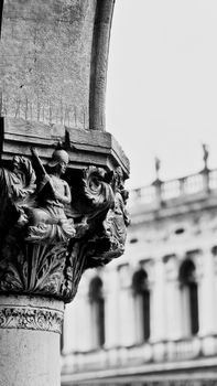 Detailed stone carvings on Venetian columns in black and white.