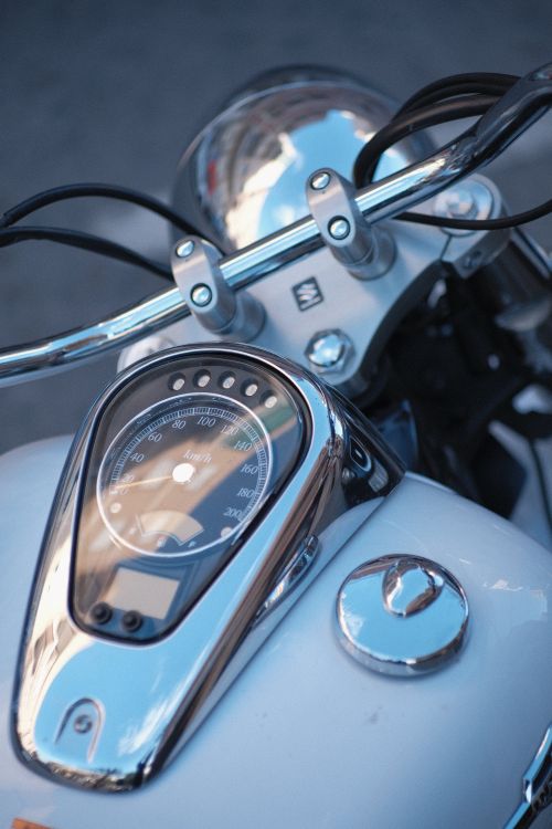 Free Detailed view of a motorcycle dashboard and chrome handlebars in sunlight. Stock Photo