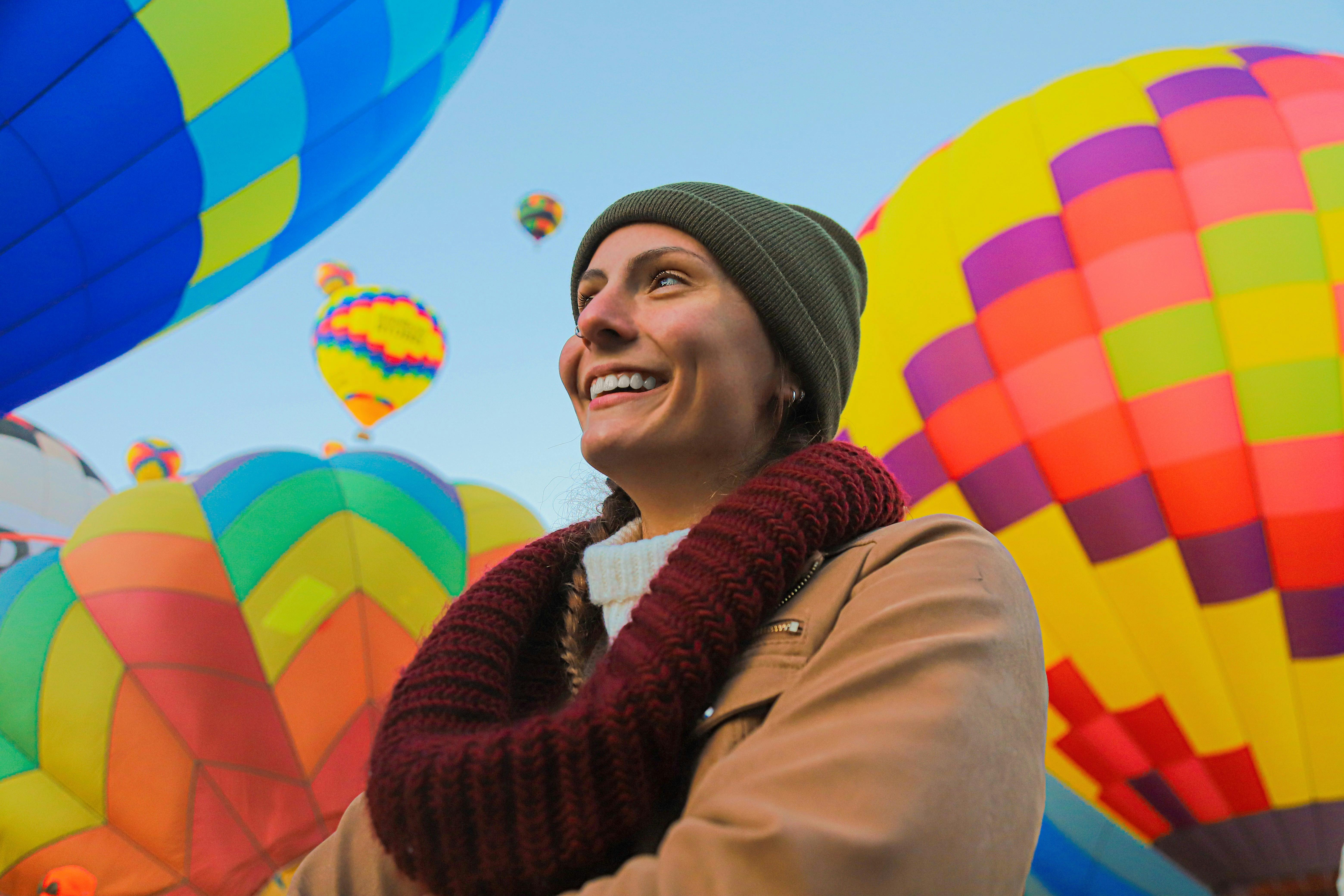 在冬天的衣服包围下，微笑的女人充满活力的热气球