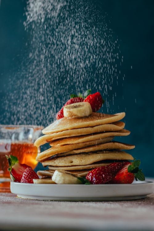 Free Stack of homemade pancakes drizzled with syrup, topped with fresh strawberries and banana slices. Stock Photo