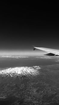 Breathtaking view of a snow-covered mountain peak taken from an airplane window.