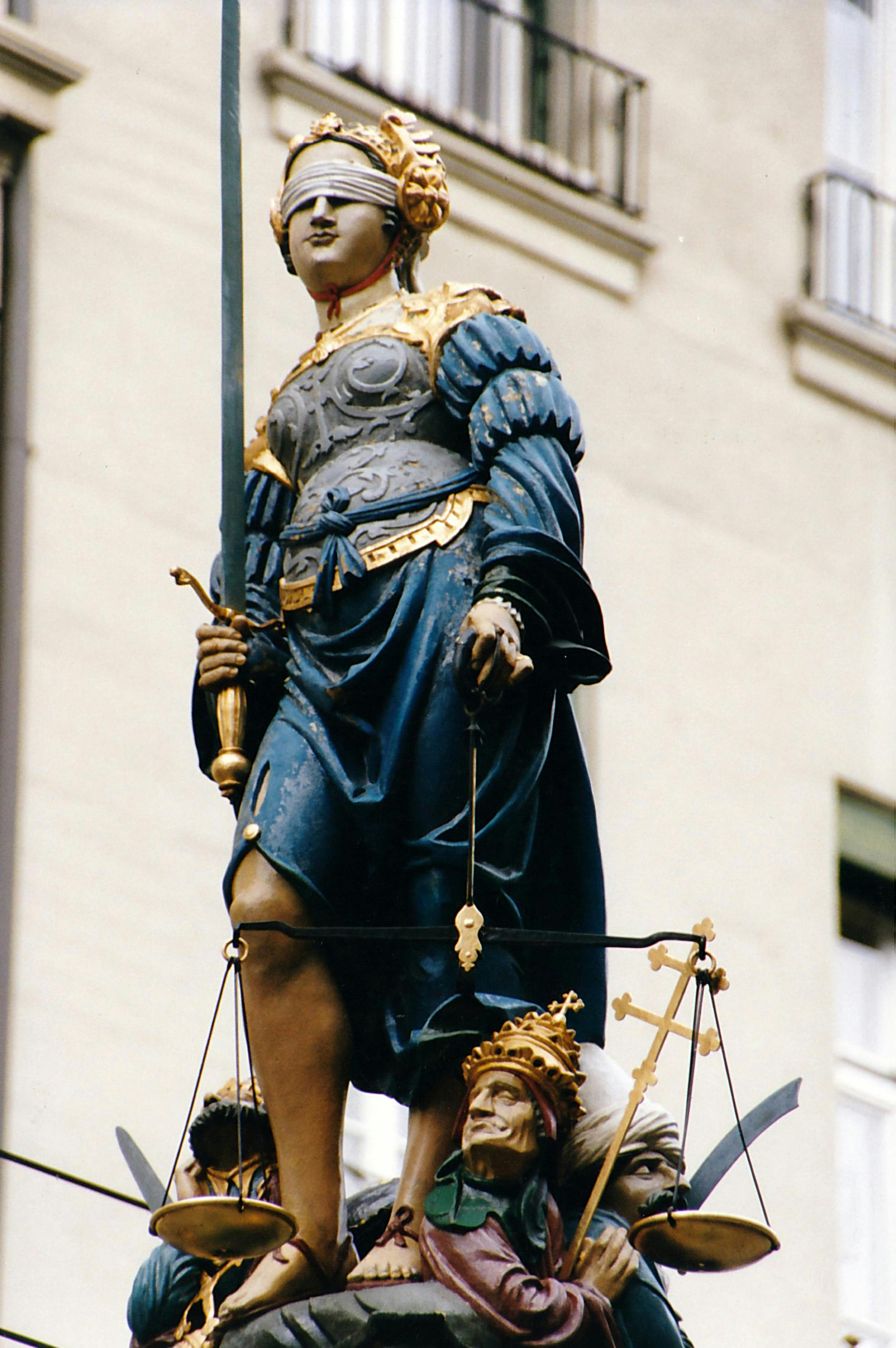 Majestic statue of Justice holding sword and scales, symbolizing fairness.