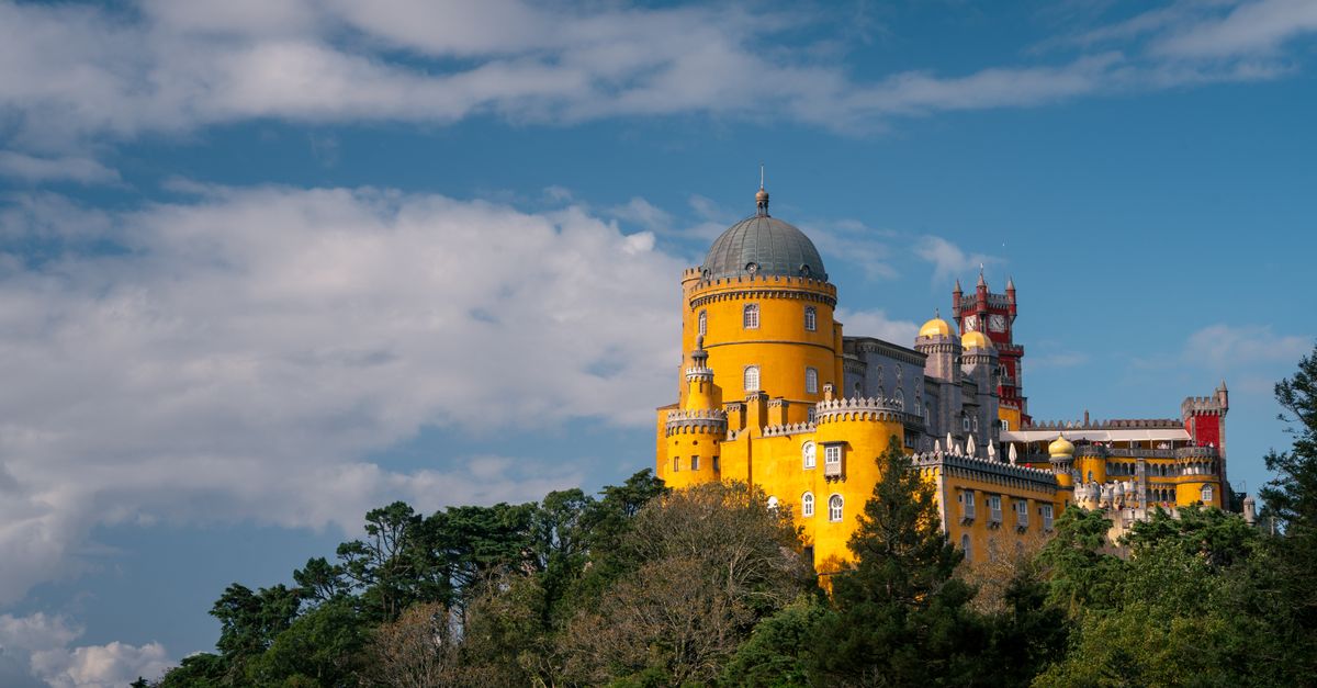 Stunning view of the colorful Pena Palace in Sintra, Portugal on a sunny day.