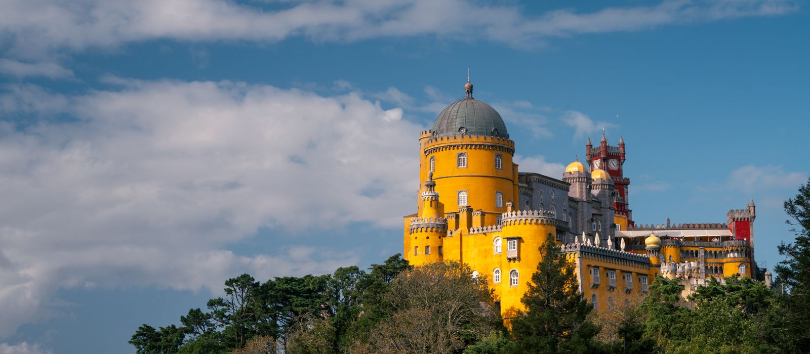 Stunning view of the colorful Pena Palace in Sintra, Portugal on a sunny day.