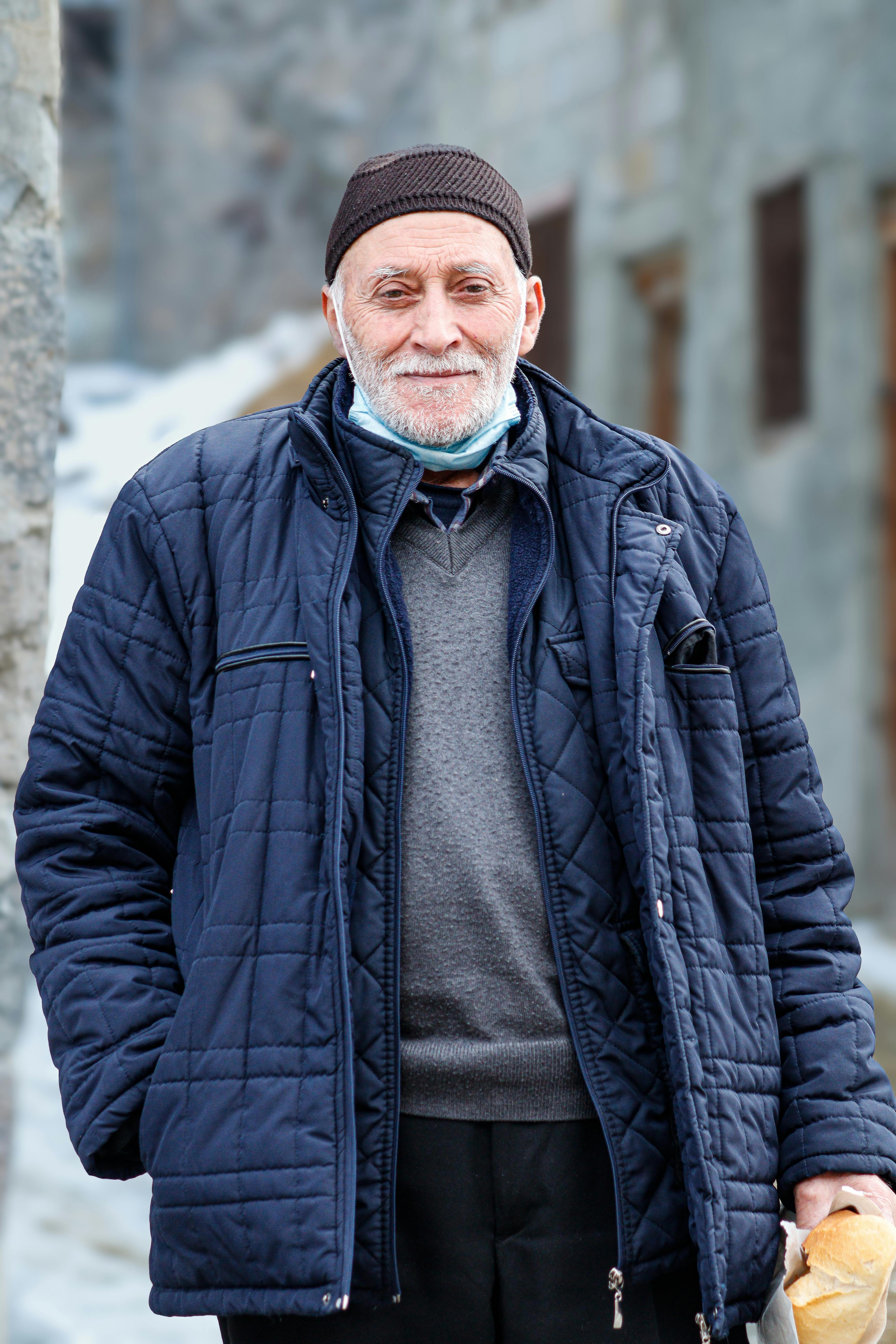 Elderly man smiling outdoors in winter