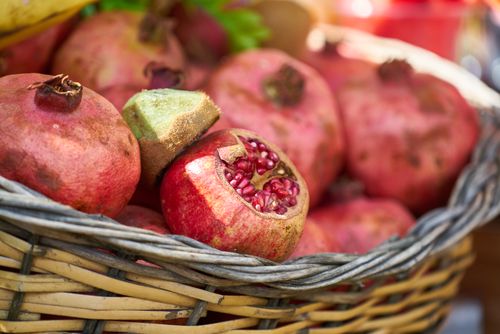 Free Close-up of ripe pomegranates in a basket, showcasing their fresh and juicy appearance. Stock Photo