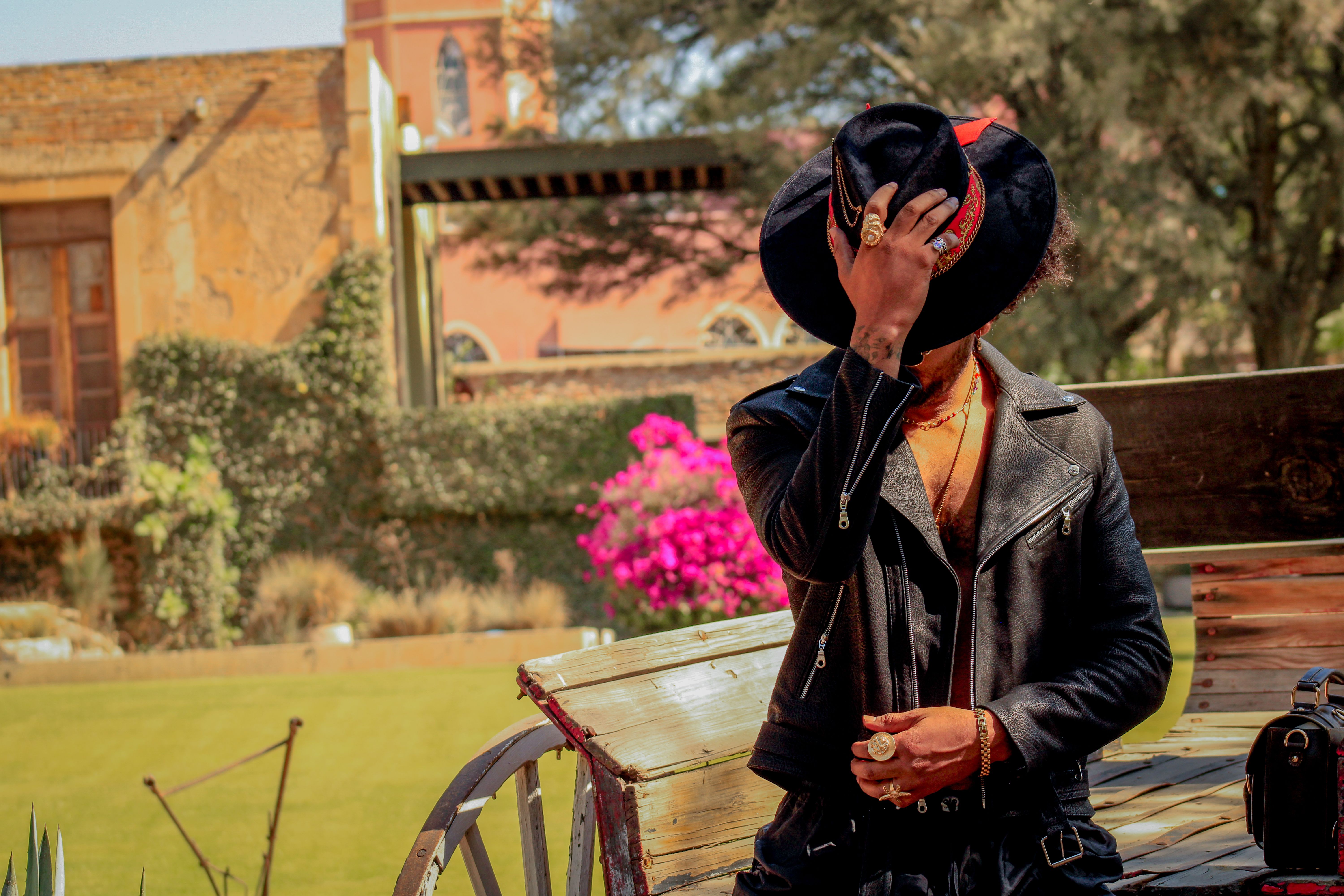 Fashionable man in a leather jacket and hat, posing outdoors in Ibarrilla, Mexico.
