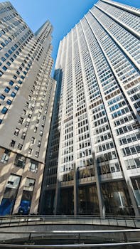 Upward view of modern skyscrapers in urban setting, showcasing architectural design.