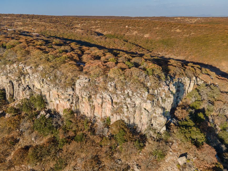Ultimate Helicopter Scenic Flight over Victoria Falls 12-13 Minutes Flight Review Review 2026 - A breathtaking aerial view showcasing rocky cliffs and autumn foliage in a forested landscape.