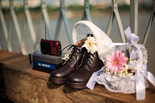 Rustic wedding setup with boots, flowers, and vintage items on a wooden surface.