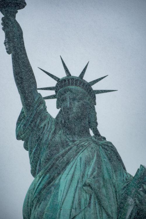 Free The Statue of Liberty stands resilient amidst a winter snowstorm, capturing historical significance. Stock Photo